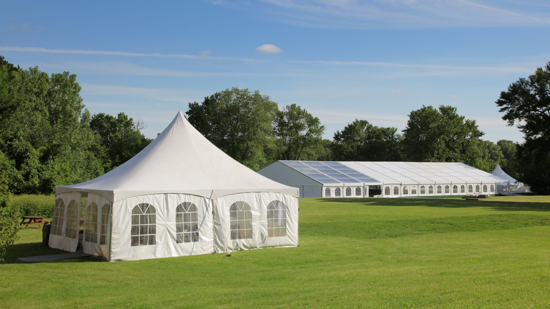 A white aluminium-based tent in a grassy field