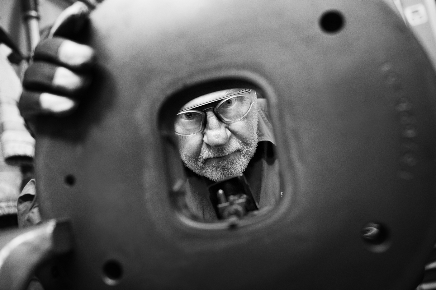 Worker looking through steel die