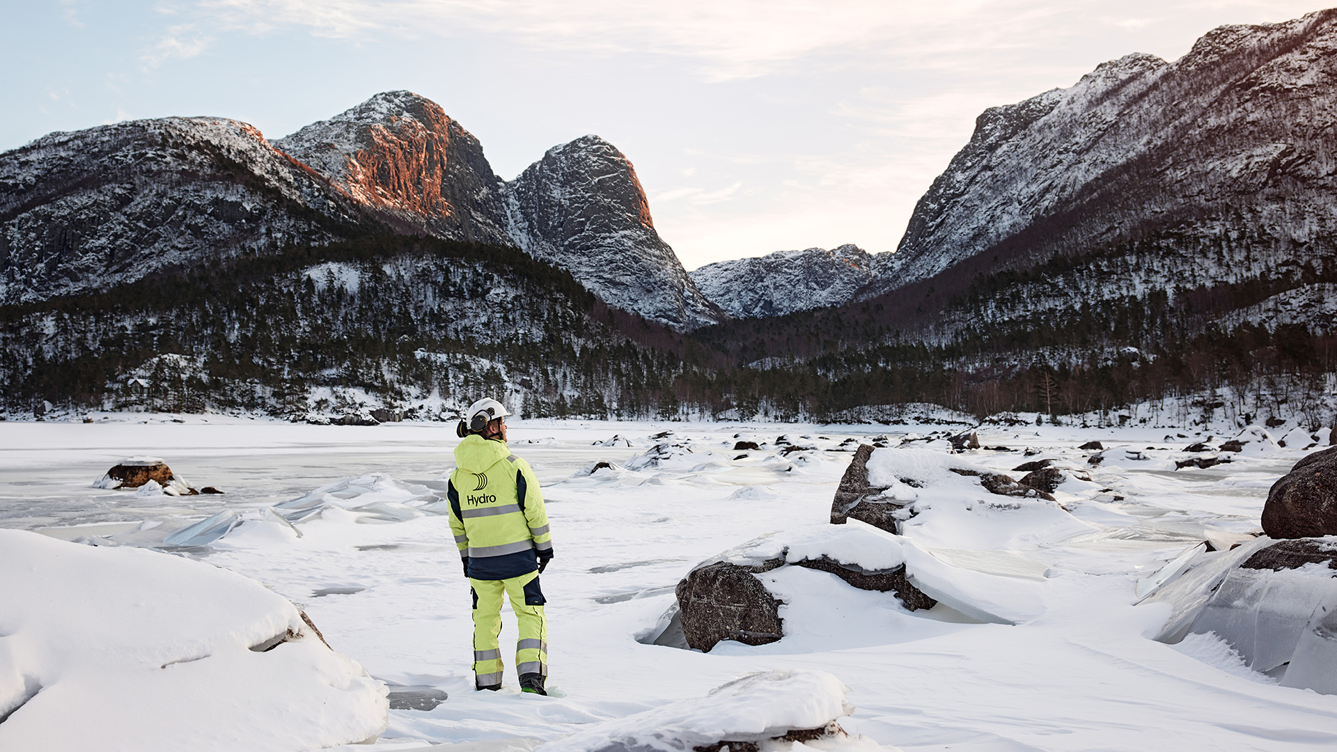 a person in a yellow suit standing in a snowy area