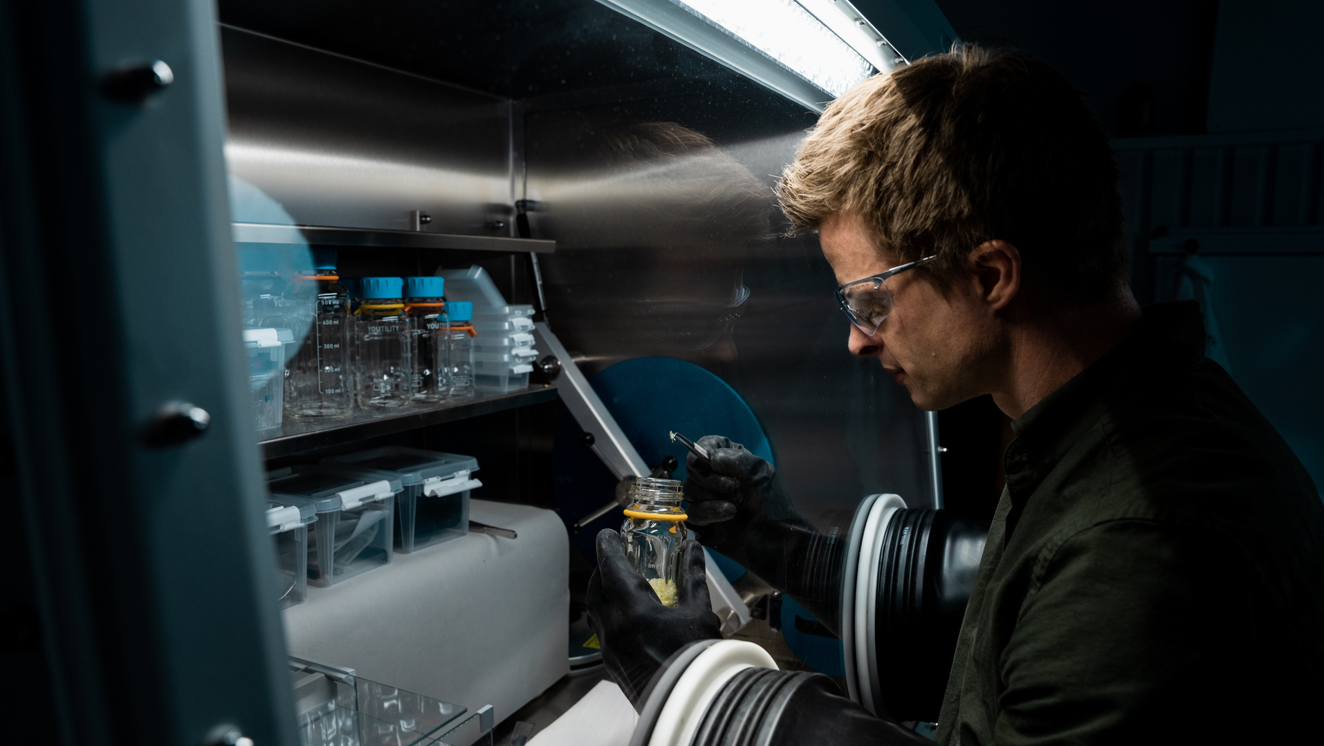 a man in a lab holding a bottle