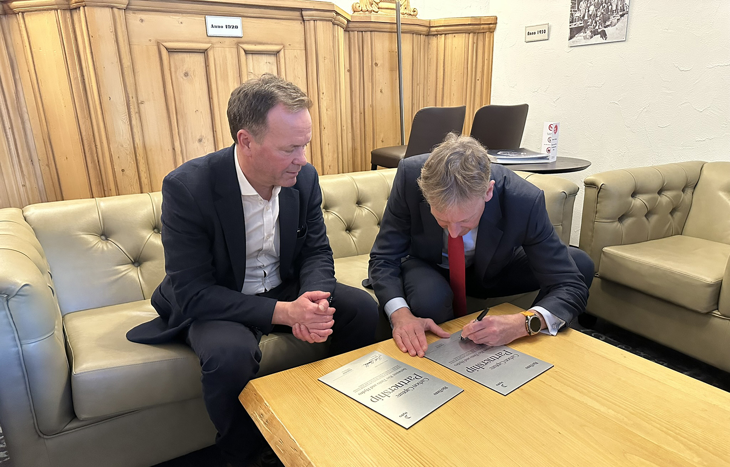 a person showing a person signing a partnership