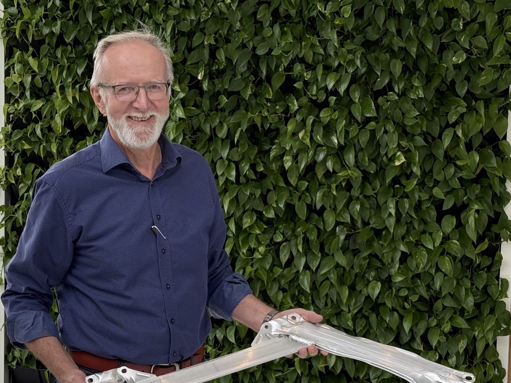 a man holding a piece of aluminium