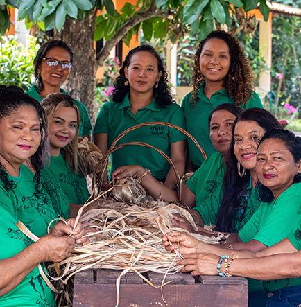 a group of women in green shirts holding a basket with a basket