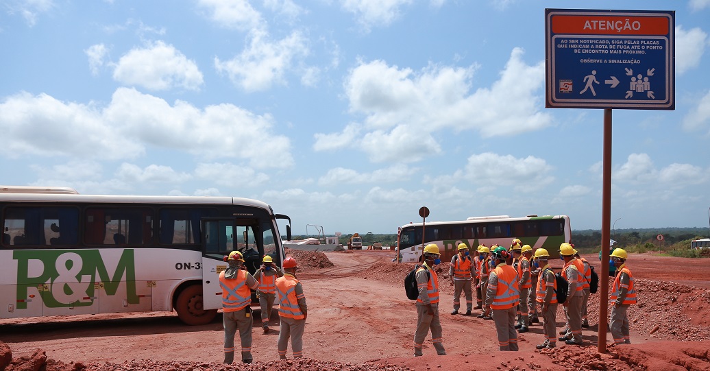 a group of people stand near some buses